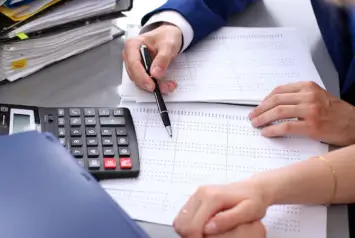 profissionais analisando registros e documentos para realizar a escrituração contábil