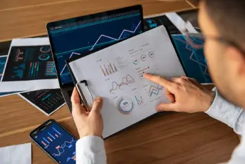 analista estudando gráficos e relatórios para planejamento e análise financeira