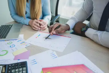 profissionais analisando gráficos e documentos durante auditoria ou fiscalização contábil