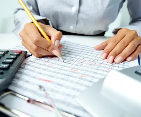 profissional registrando lançamentos contábeis durante processo de escrituração fiscal