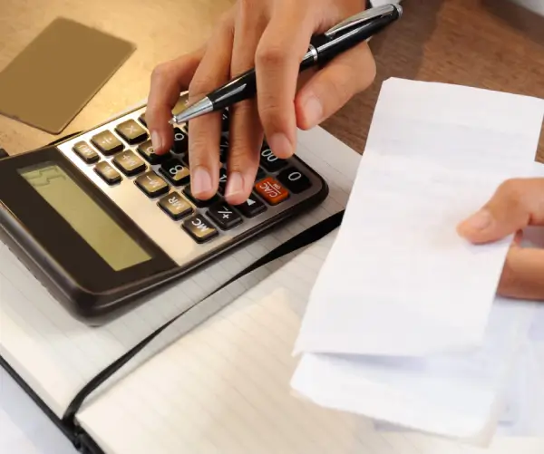 profissional conferindo valores e cálculos para gestão da folha de pagamento