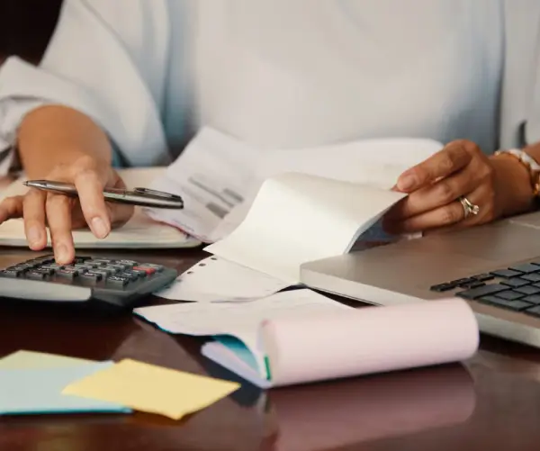 profissional conferindo documentos e cálculos para preparar a declaração do Imposto de Renda