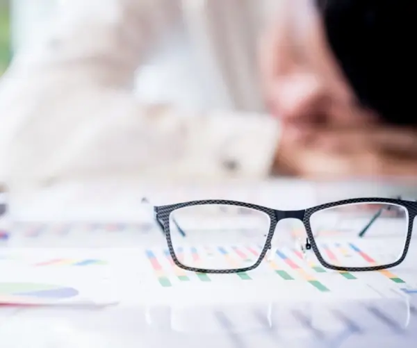 profissional trabalhando ao fundo enquanto analisa documentos para auditoria fiscal