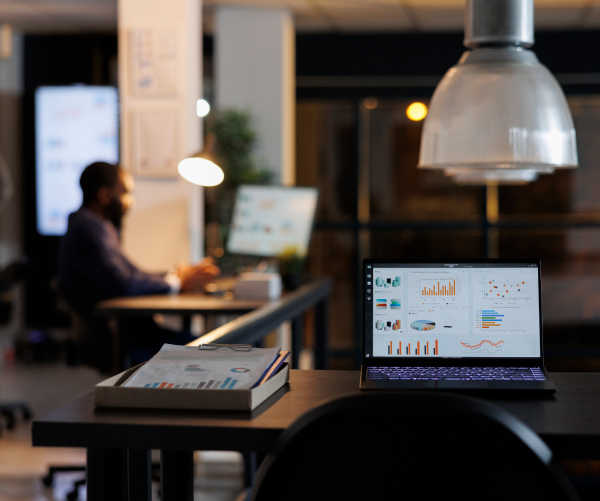 Estação de trabalho com relatórios financeiros exibidos em notebook em escritório contábil