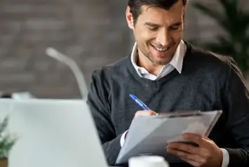 Contador analisando documentos sobre reforma tributária em escritório contábil